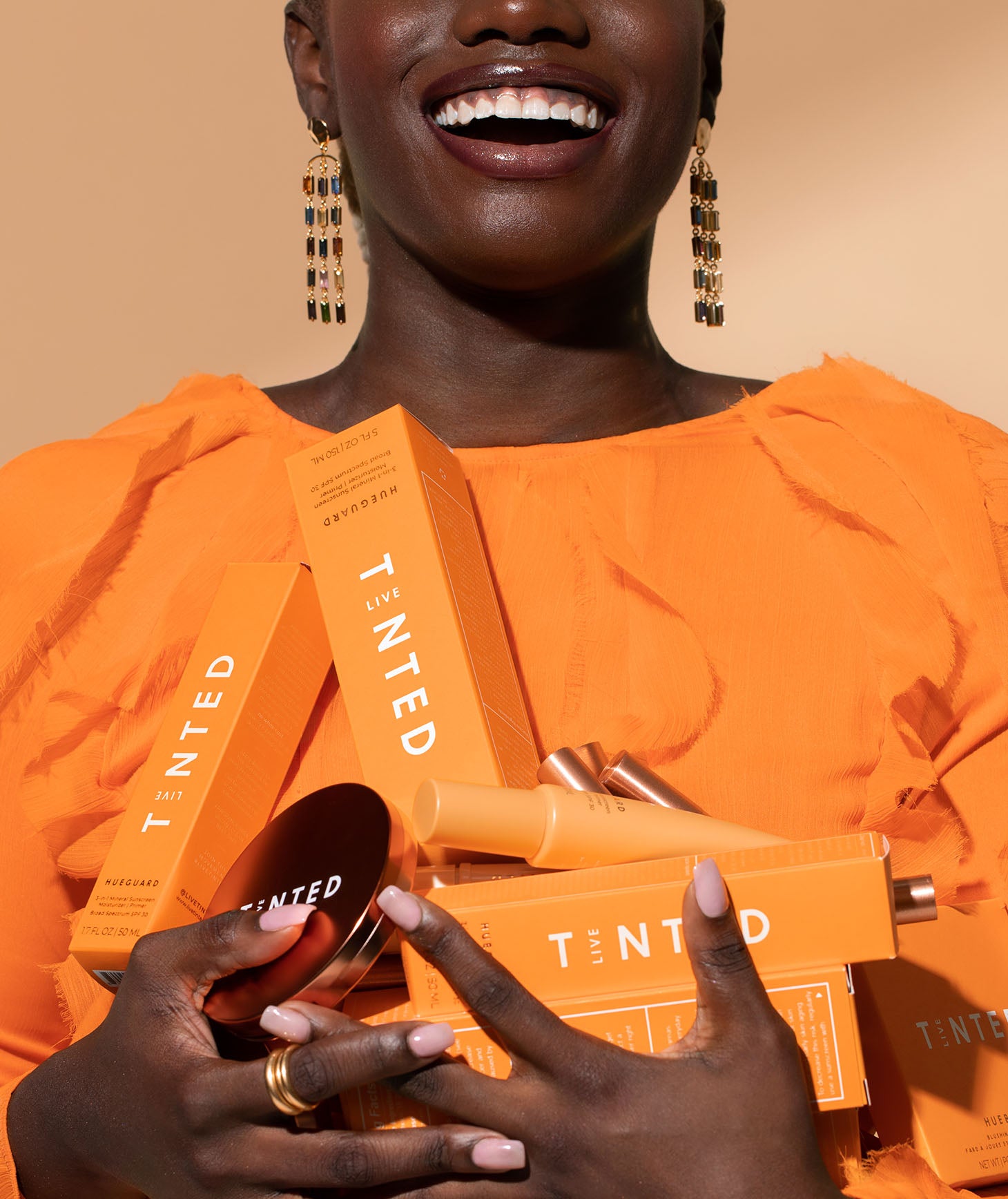 Image of model holding several Live Tinted products